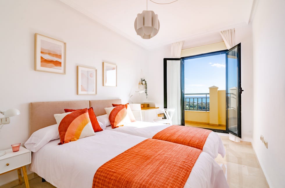 dormitorio con dos camas individuales y acceso a la terraza