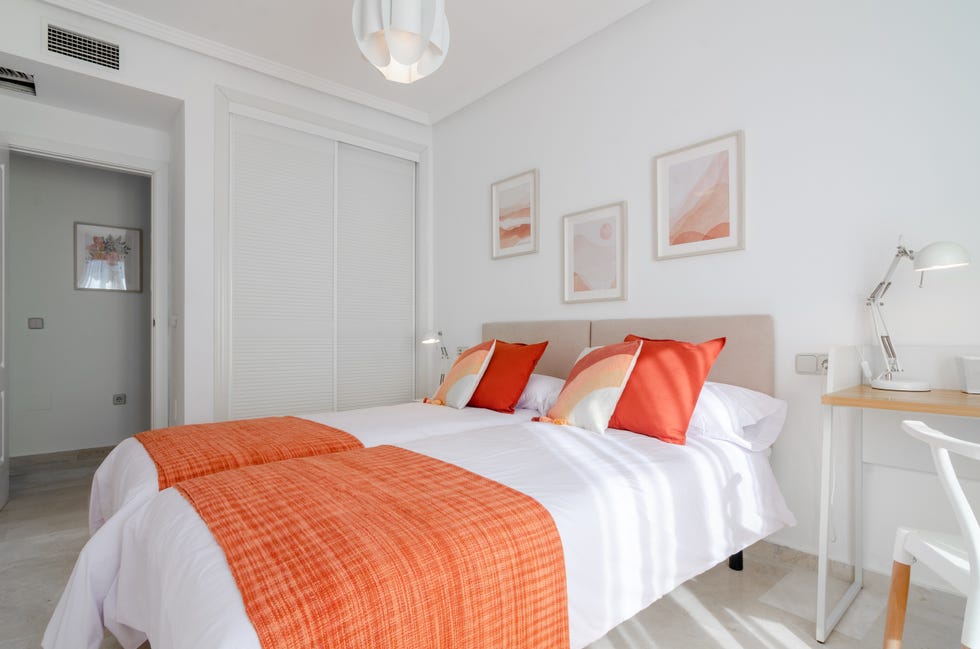 dormitorio con dos camas individuales y acceso a la terraza