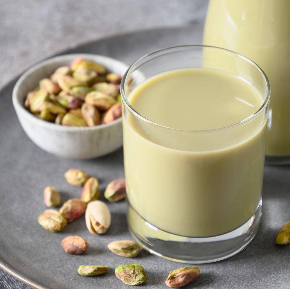 pistachio milk in glass, lactose free. vegan plant based milk.