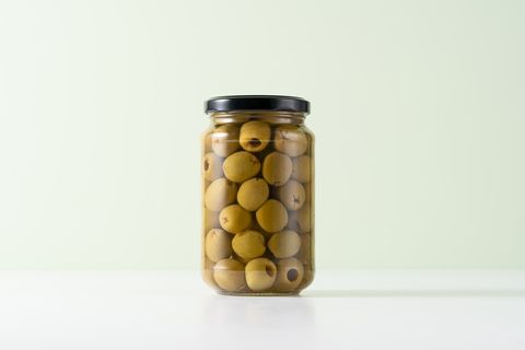 pitted green olives in a glass jar