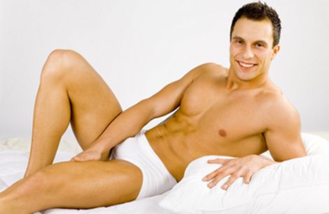 smiled and happy man lying on the bed white background in studio