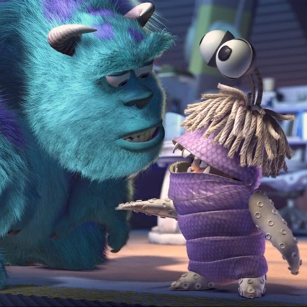 sully kneels down to look at boo in a monster costume