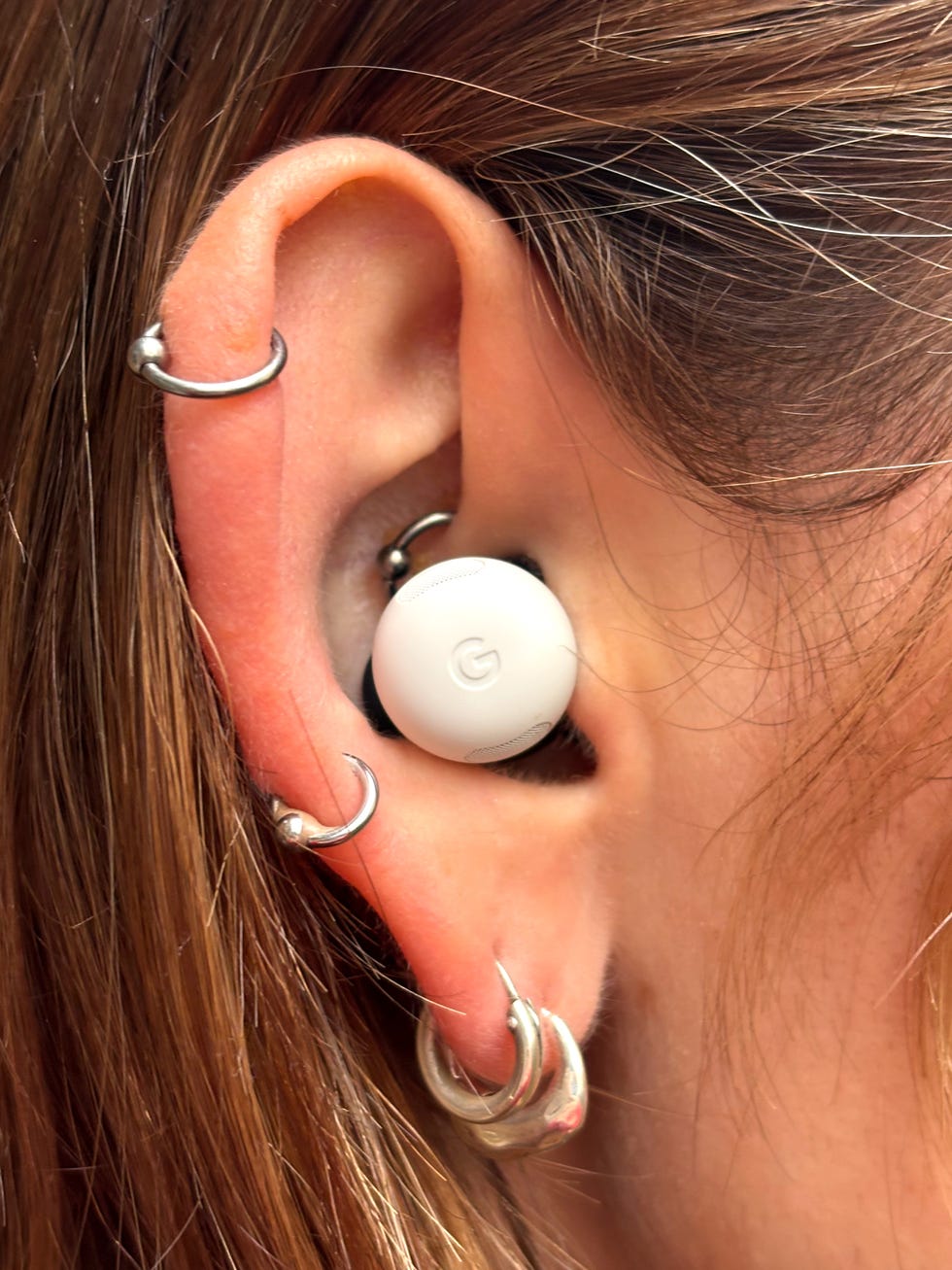 close up of a white google pixel bud pro 2 in a woman's ear