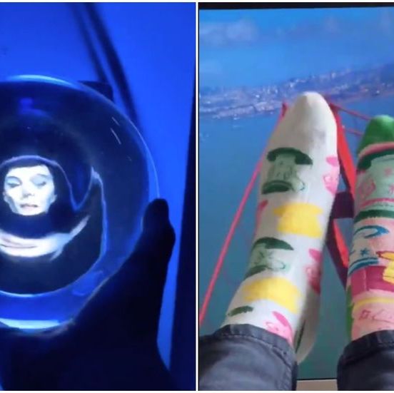 woman holding Haunted mansion orb and feet in air over photo of golden gate bridge