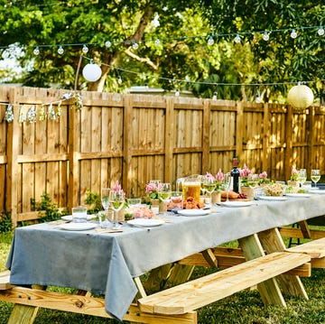 picnic table set up in a garden with floral decor and food