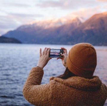 a man taking a picture of the sunset