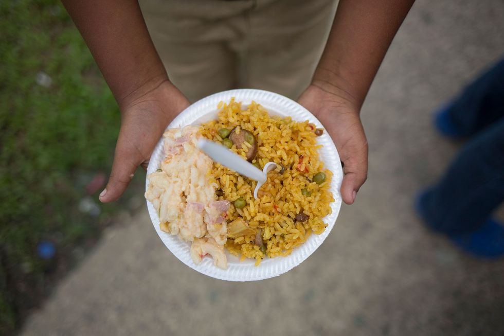 Een jongen houdt een bord met eten vast dat hij kreeg van vrijwilligers bij de Pinksterkerk Jesucristo Monte Moria in Naguabo in Puerto Rico die deel uitmaken van het team dat met Andrs samenwerkt