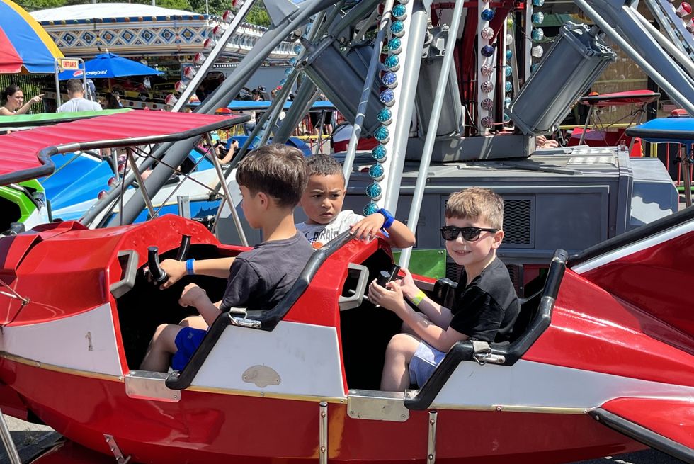 a group of boys riding in a small amusement park ride