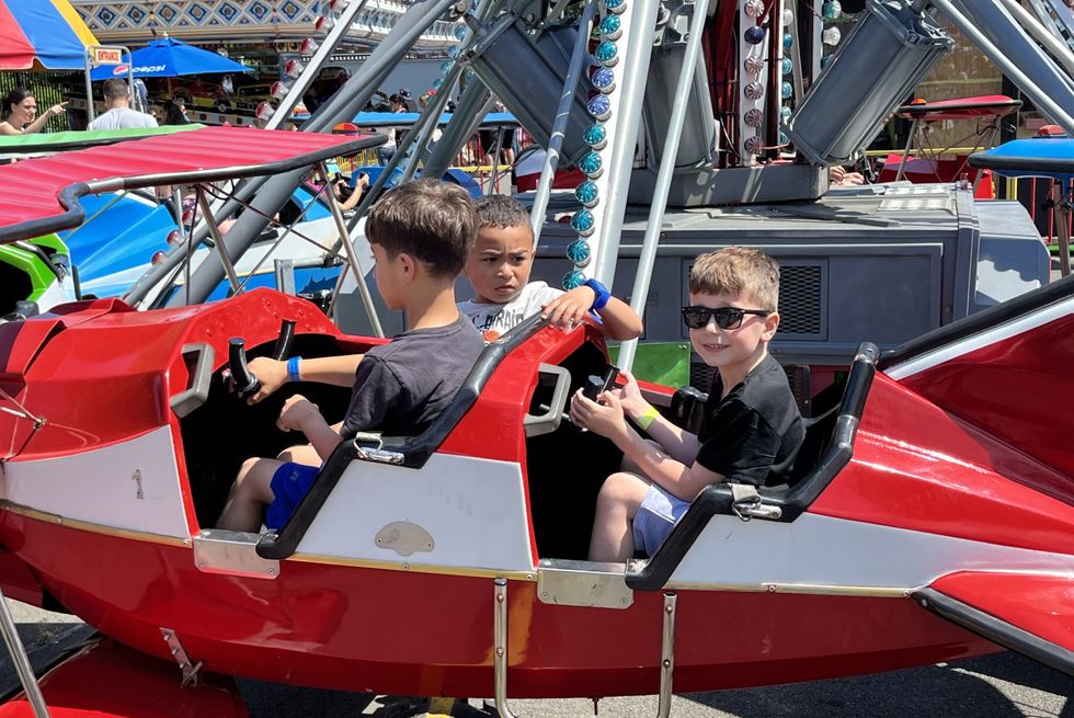 a group of boys riding in a small amusement park ride