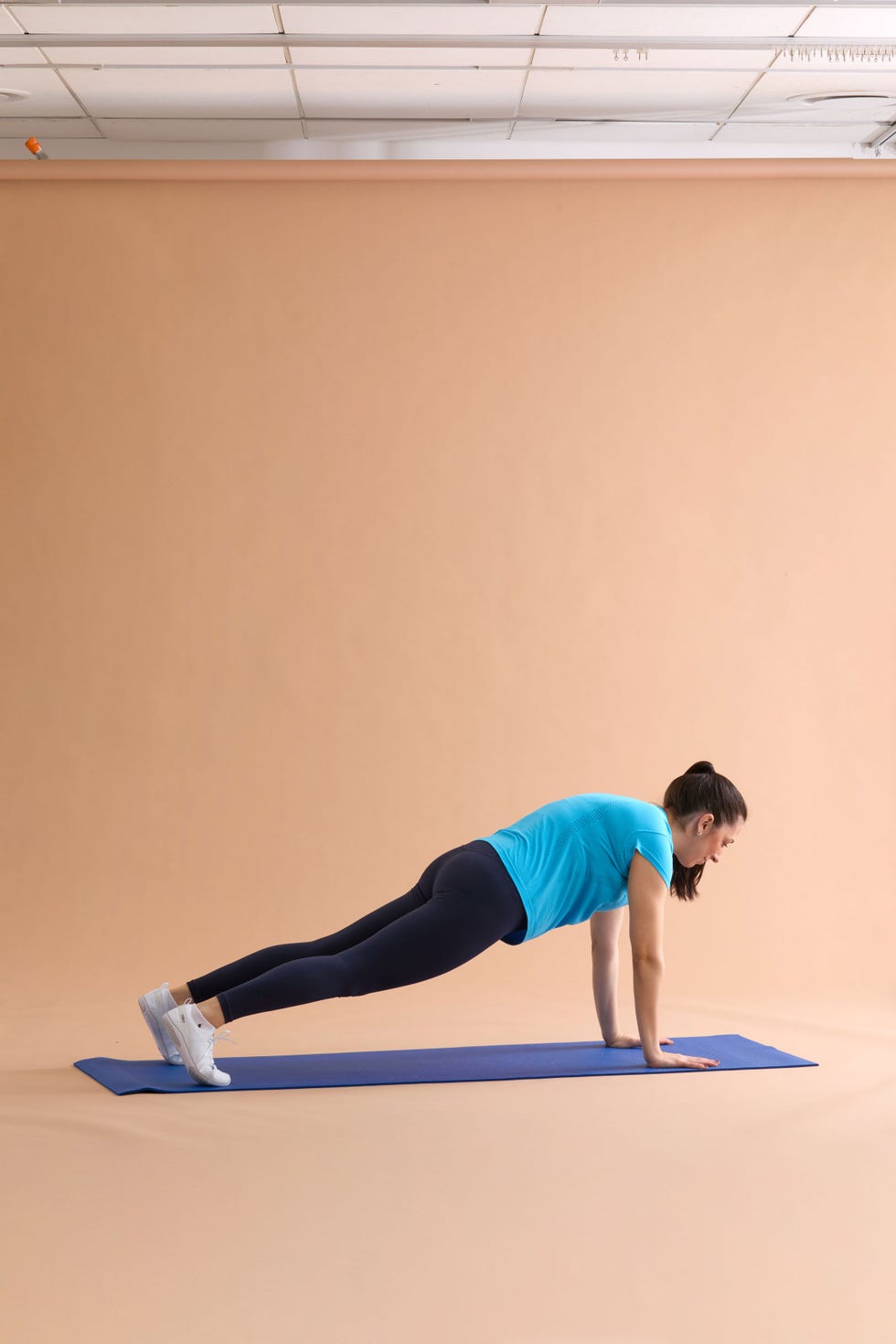 A person performing a plank exercise on a yoga mat