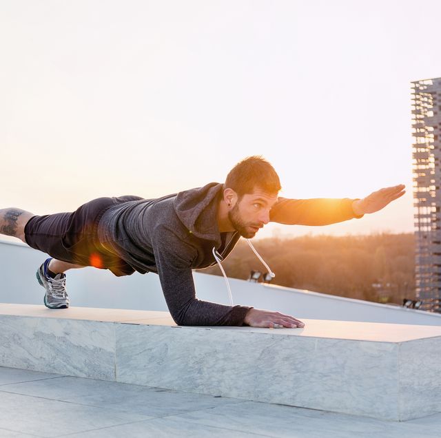 mid adult man exercising outdoors, in yoga position