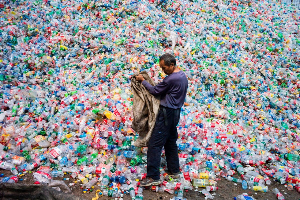 Een Chinese arbeider sorteert plastic flessen op een recyclingbedrijf in het dorp Dong Xiao Kou in de buitenwijken van Beijing