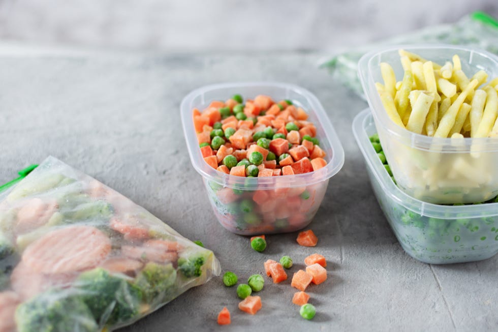 plastic containers and bags with different frozen vegetables