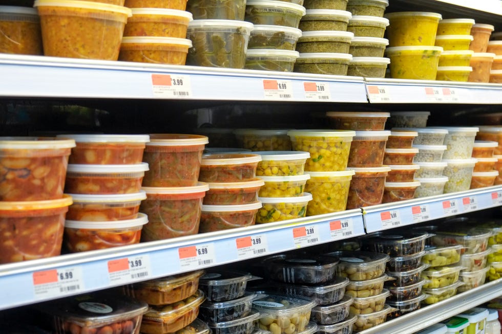 Plastic containers with food on supermarket shelves