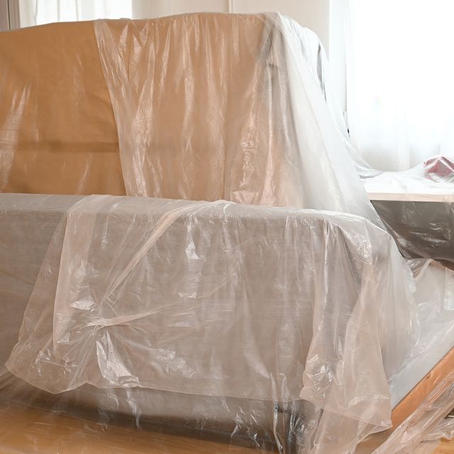 plastic covering furniture and belongings in a living room