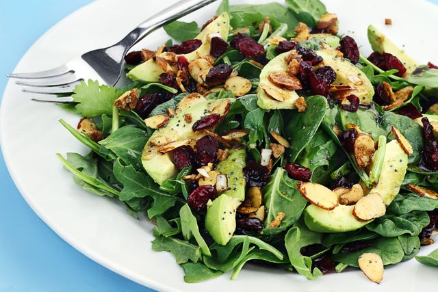a plate of healthy avocado almond spinach salad