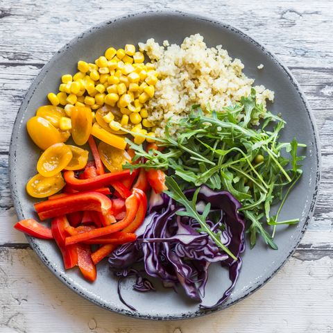 Plate of rainbow salad with bulgur, rocket and different vegetables