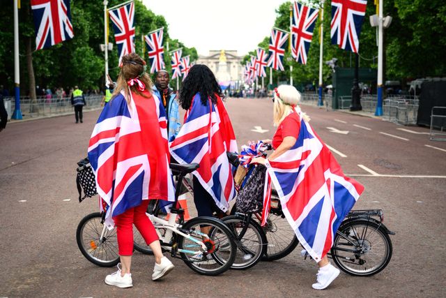 members of the public look towards buckingham palace as they cycle along the mall ahead of the upcoming jubilee events