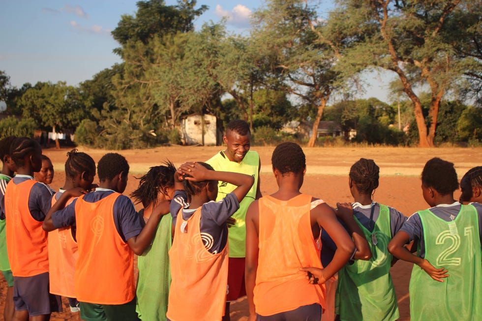a group of young football players wearing team vests