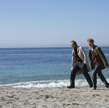 two people walking on a beach