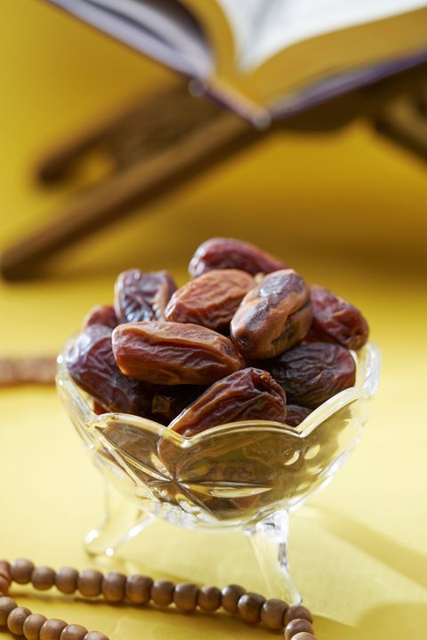 player beads,koran and dry fruit date against yellow background,malaysia