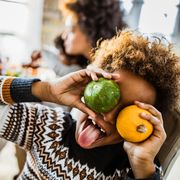 thanksgiving riddles  playful young child having fun with small pumpkins in dining room