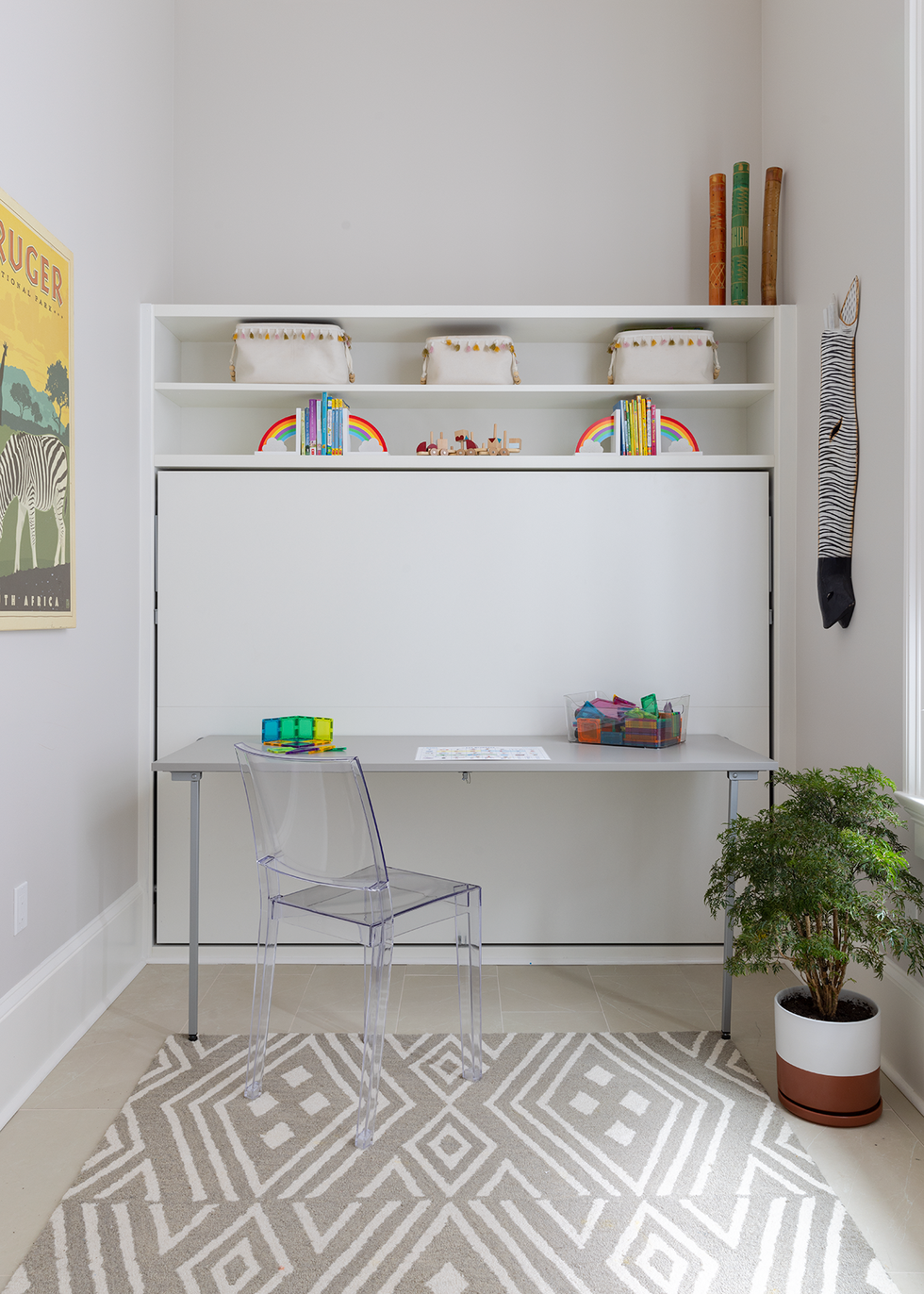a white shelving unit with a white table and a plant