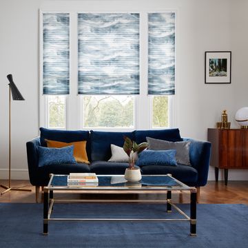 salón blanco con sofá y alfombra en azul