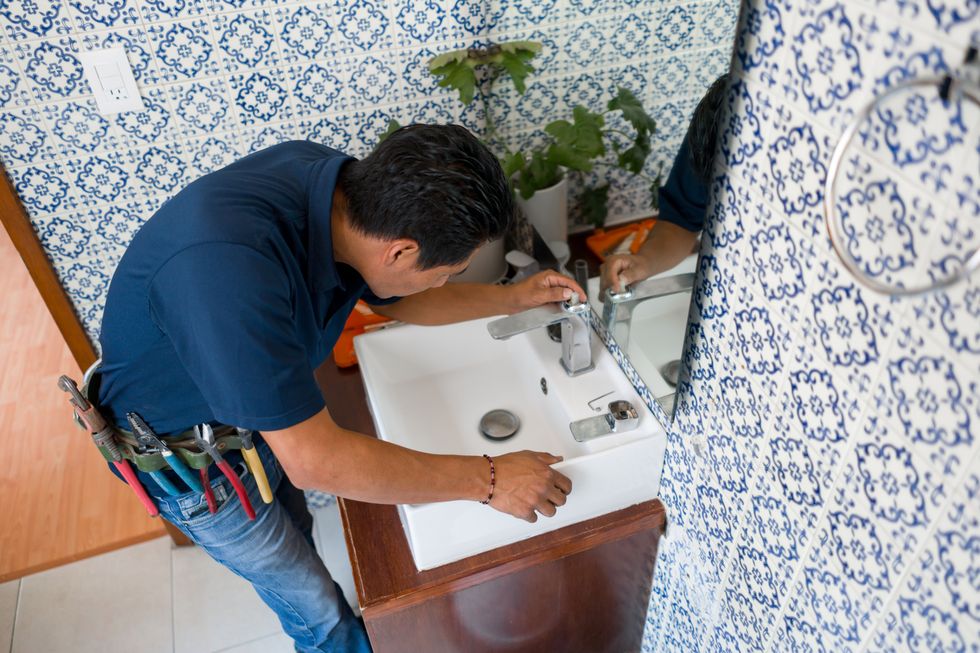 plumber installing a faucet in a bathroom's sink