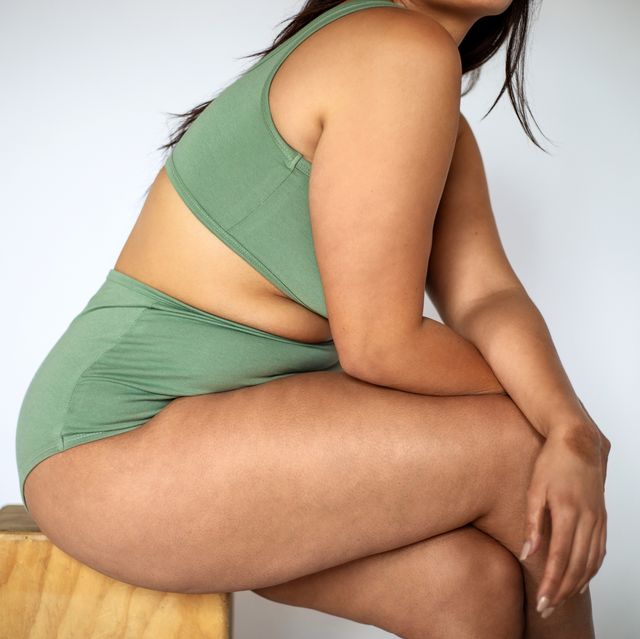 plus size woman in lingerie sitting on a stool