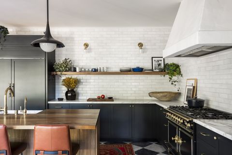 sarah solis kitchen, black cabinets, white subway tiles, wooden island, tan leather bench stools