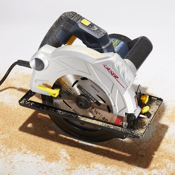 circular saw and sawdust on white surface