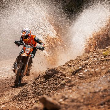 ktm's two stroke blasting through a puddle