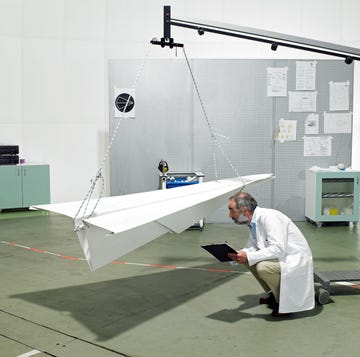 a scientist inspects a large paper airplane