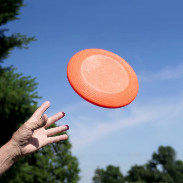 a frisbee leaves a hand against a blue sky background a frisbee leaves a hand against a blue sky background