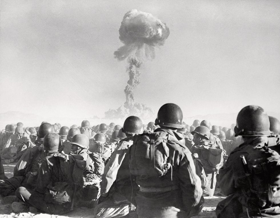 a group of soldiers watching atomic bomb detonation