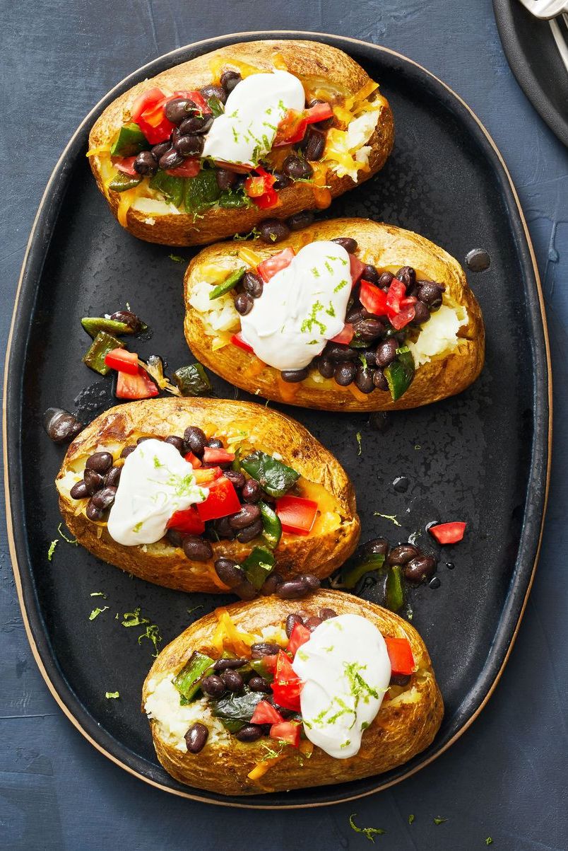 poblano and black bean loaded baked potatoes with dollops of cream on top
