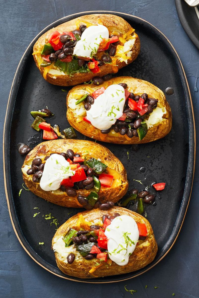 poblano and black bean loaded baked potatoes with dollops of cream on top