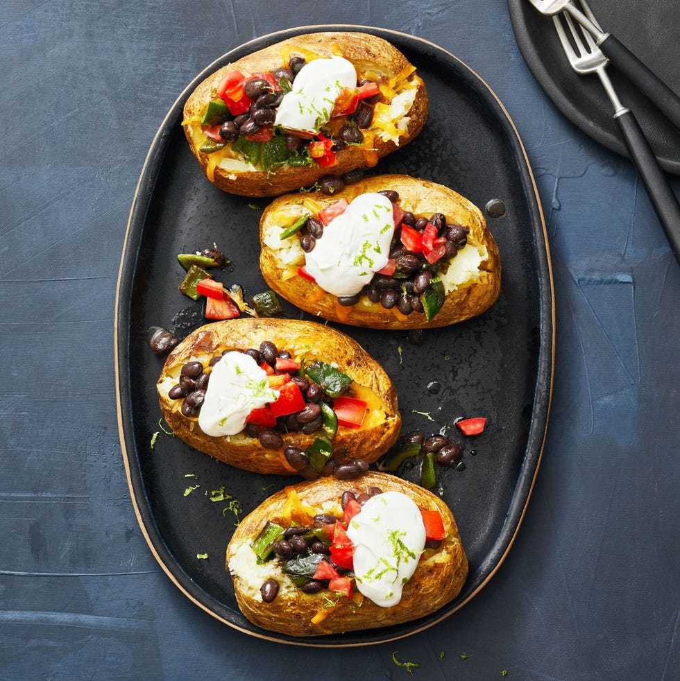 poblano and black bean loaded baked potatoes with dollops of cream on top