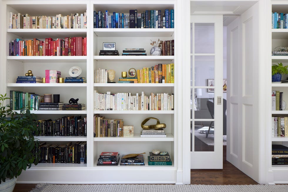 a neatly organized bookshelf with a variety of books in different colors and sizes and pocket doors