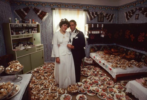 Na hun bruiloft in een klooster in het noordoosten van Roemeni wacht een echtpaar tot hun receptie begint Dit portret uit de editie van december 1983 toont een kamer vol voorgerechten hier zal het hele dorp zich binnenkort verzamelen om te eten
