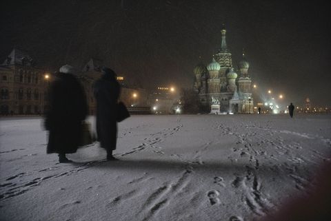 Vrouwen lopen door de sneeuw naar de SintBasiliuskathedraal in Moskou De bouw van de kerk eigenlijk Kathedraal van de Voorbede van de Moeder Gods op de Greppel geheten begon in 1555 onder Ivan de Verschrikkelijke