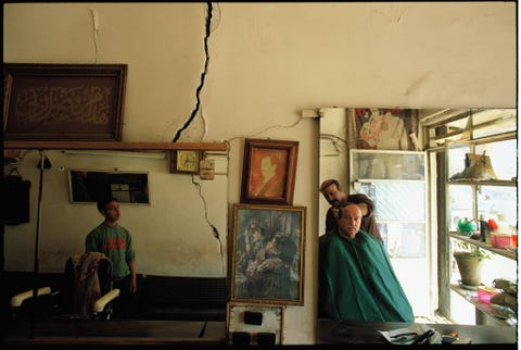 Een kapperszaak in Bagdad Irak draagt de littekens van bombardementen Deze foto verscheen in de september 2003 editie slechts zes maanden nadat de Verenigde Staten Irak binnenvielen