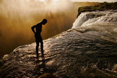 Met de 102 meter lange val van Zambias Victoriawatervallen slechts centimeters van hem verwijderd staat een zwemmer aan de rand van een verborgen poel  een 2 meter diepe groep in de rotsen van het rivierbed  die enkel bereikbaar is wanneer het water in de Zambezirivier laag staat
