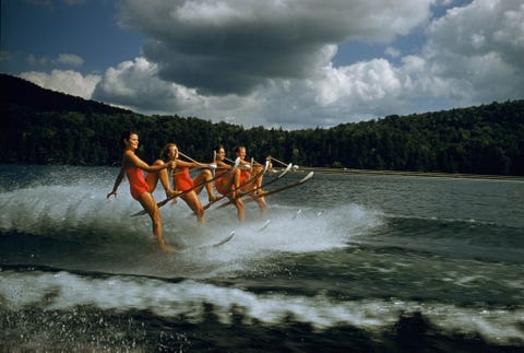 Een vrouwen waterskiteam voert een gesynchroniseerde routine uit met een snelheid van 37 kilometer per uur op het Dart Lake New Yorkmidden jaren 50