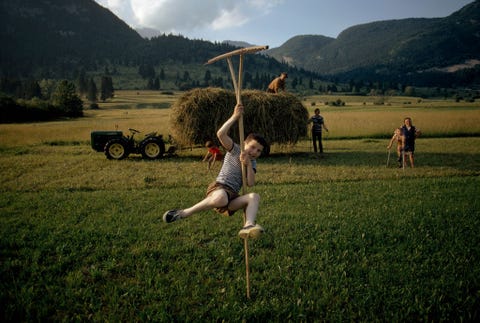 Op een boerderij bij het meer van Bohinj in Sloveni doet een jongen alsof hij met een soort hooihark een grablje genaamd een polsstoksprong maakt De boerderij werd vastgelegd in een boek over de Alpen door James P Blair