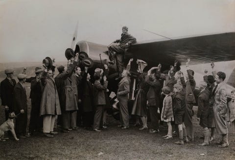 Amelia Earhart klimt uit haar vliegtuig na het voltooien van haar transatlantische solovlucht in 1932 Deze foto verscheen in het maartnummer van dat jaarEarhart was ook de eerste vrouw die de speciale gouden medaille van de National Geographic Society ontving