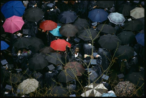 Een regenachtige ceremonie kan deze man er niet van weerhouden om te vieren dat hij zojuist zijn diploma heeft behaald aan de Columbia University Deze foto verscheen oorspronkelijk in het septembernummer van 1990 in een verhaal dat de hele lengte van Broadway in New York City aflegde