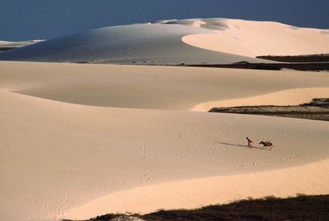 Een reiziger en ezel lopen over zandduinen bij Fortaleza in het noordoosten van Brazili Dit verhaal uit het nummer van maart 1987 onderzocht wat het betekende om Braziliaan te zijn slechts een paar jaar nadat een nieuwe burgerregering was aangesteld