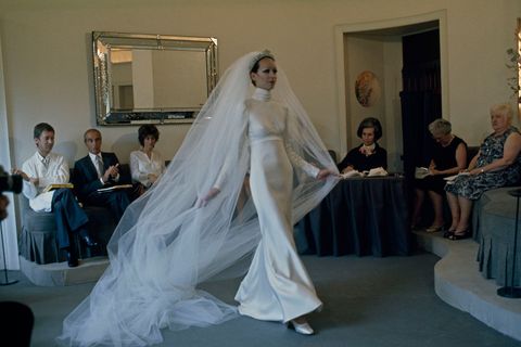 Een model draagt een op maat gemaakte bruidsjurk op een Parijse modeshow in de vroege jaren 70